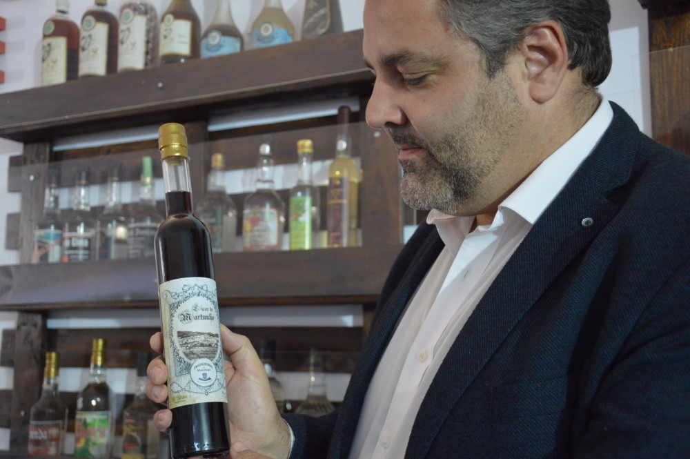 Rui André com uma garrafa do seu licor de martunho, que ele próprio produz (só para a família e amigos) e de cujo rótulo é também autor