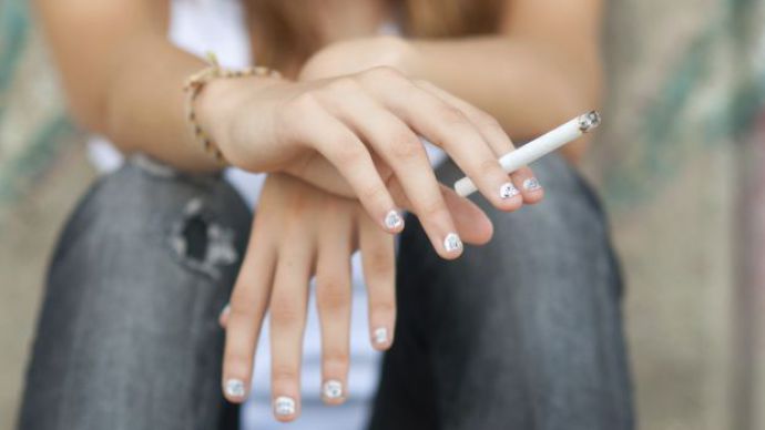 Teenage hands holding cigarette