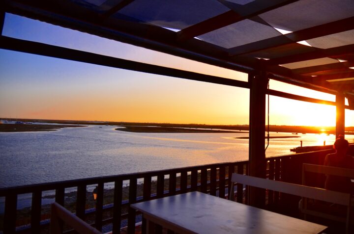 Photo of a seafront esplanade with a view to the Ria Formosa and a beautiful sunset.
