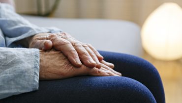 Elderly woman sitting alone at home