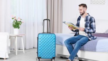 Young man reading magazine in hotel room