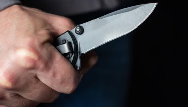 Man holding a knife in a threatening stance ready to fight