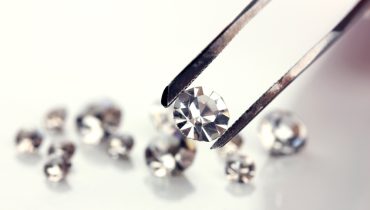 Beautiful shining crystal (diamond) in the tweezers