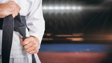 Fighter tightening karate belt against composite image of playing field indoor|Cartaz_CN_Juniores_2024-_4_-JUDO jpg