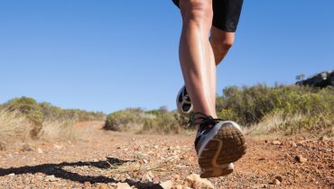 Athletic man jogging on country trail on a sunny day